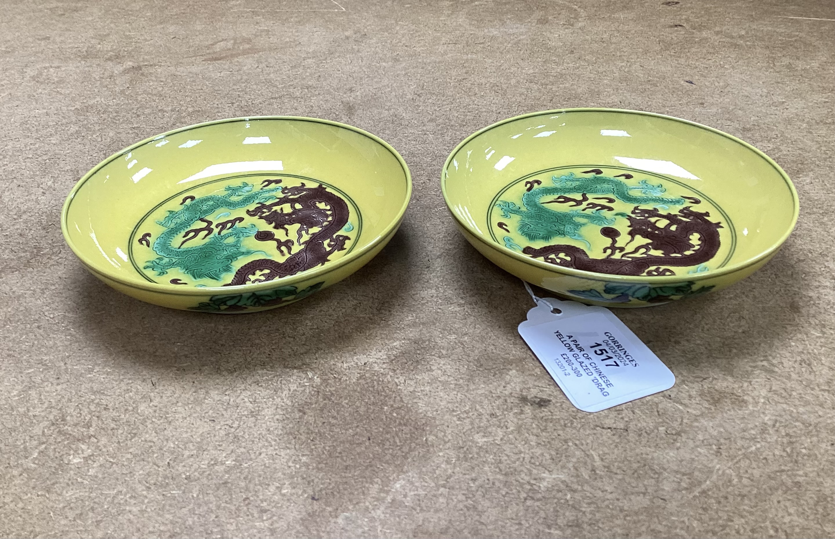 A pair of Chinese yellow glazed ‘dragon’ dishes, 13cm in diameter